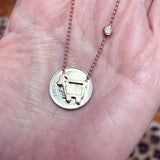 comparing the size of Julie lamb rose gold small signature lamb necklace with a coin