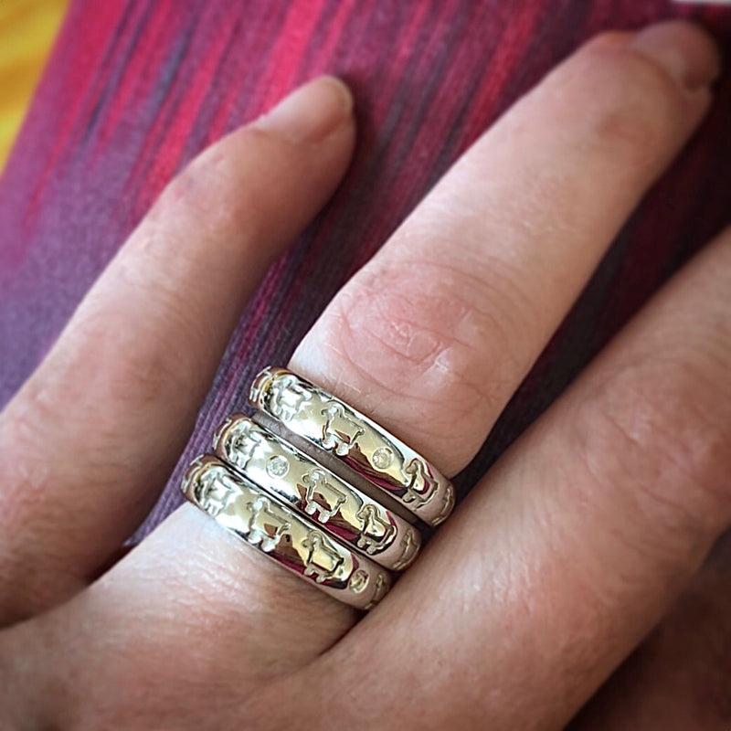 Stack of signature lamb band rings shown on finger