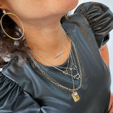 Model wearing collection of signature lamb logo necklaces designed by Julie Lamb