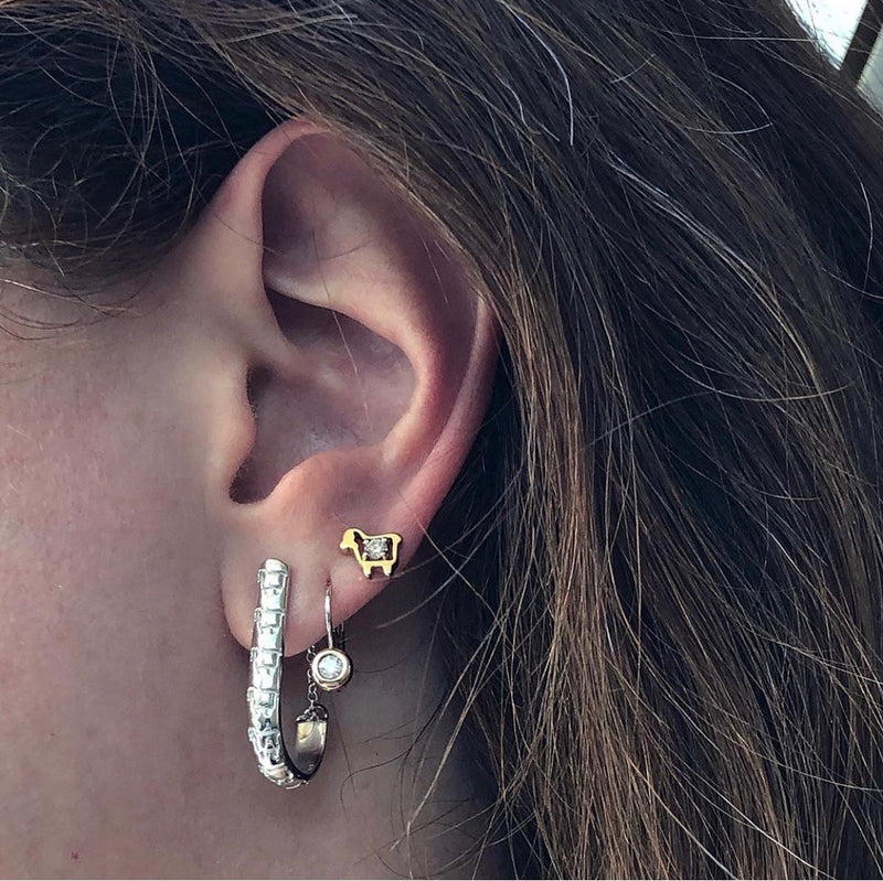 Close up on ear lamb logo hoop earrings in sterling silver