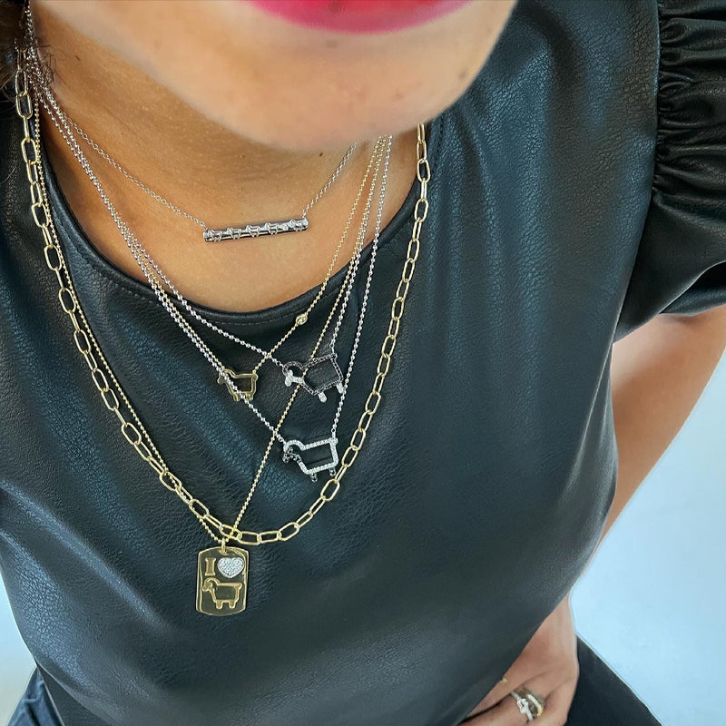 Sterling bar lam logo necklace shown with pendants worn on model