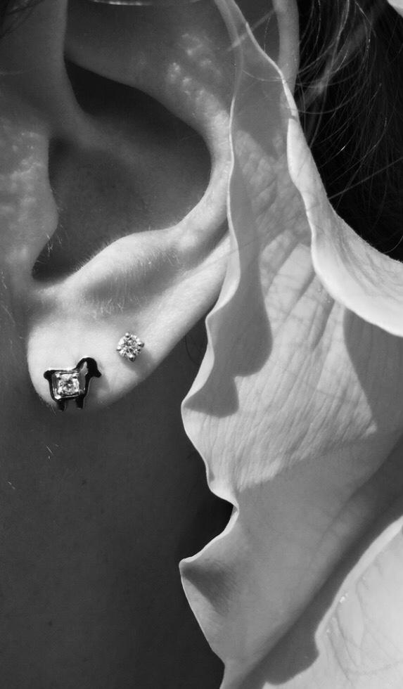 Mini sheep diamond stud earrings along with another diamond earrings on model ear