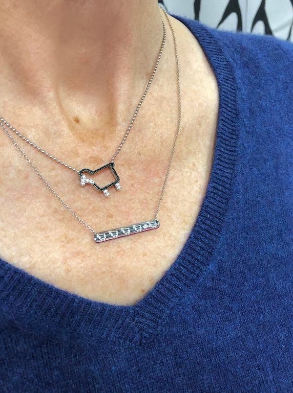 Sterling bar necklace with lamb logo worn on model
