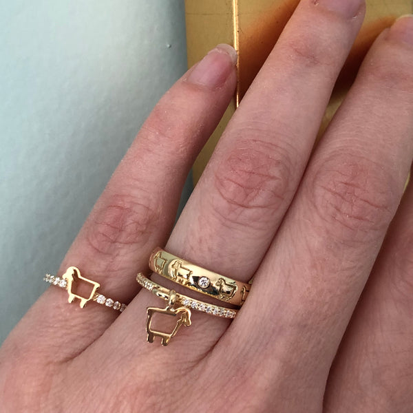 18K gold lamb logo rings stacked and shown worn on finger
